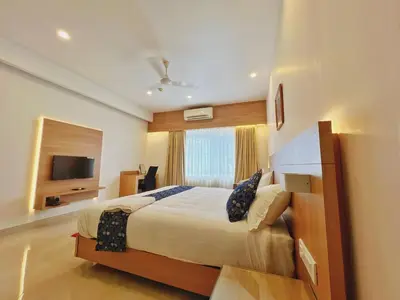 a hotel room with a bed and a television at Hotel Amaravathi BY D2V in Manattala