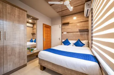 a bedroom with a bed with blue pillows at Daan Temple Inn in Guruvāyūr