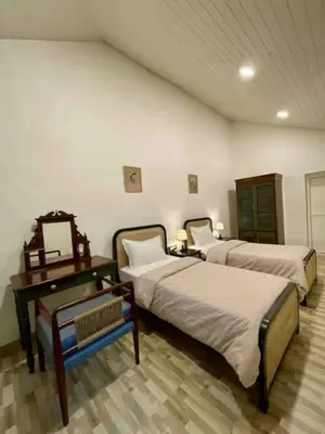 a bedroom with two beds and a desk and a mirror at Sliceinn Escapes Pushpanjali - Madikeri, Coorg in Madikeri