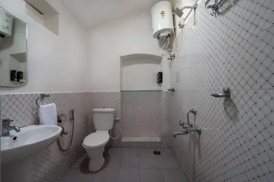 a small bathroom with a toilet and a sink at Sliceinn Escapes Pushpanjali - Madikeri, Coorg in Madikeri