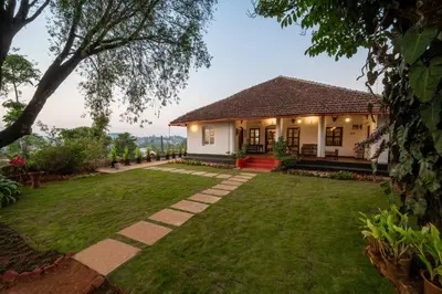 a house with a lawn in front of it at Sliceinn Escapes Pushpanjali - Madikeri, Coorg in Madikeri