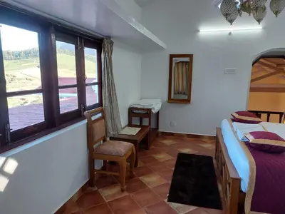 a small room with two beds and a window at Jennings Abode Doddabetta in Ooty