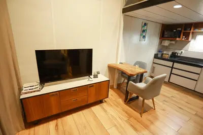a living room with a flat screen tv and a table at Shoreline Secrets in Trichūr