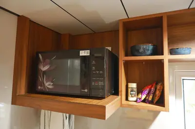 a microwave on a shelf in a kitchen at Shoreline Secrets in Trichūr