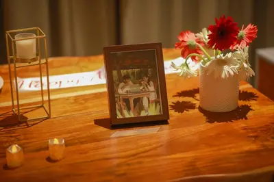 a picture frame on a table with flowers and a vase at Shoreline Secrets in Trichūr