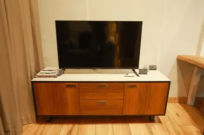 a flat screen tv on top of a wooden cabinet at Shoreline Secrets in Trichūr