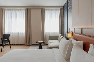 a hotel room with a bed and a chair at The Magnus in Coimbatore