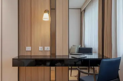 a conference room with a desk and a mirror at The Magnus in Coimbatore