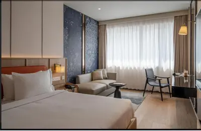 a hotel room with a bed and a chair and a couch at The Magnus in Coimbatore