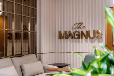 a living room with a couch and a sign on the wall at The Magnus in Coimbatore