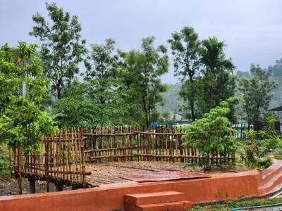 a wooden fence in a yard with trees in the background at Mana Gramam Resort Mudumalai- Only For Indians,NRI in Mudumalai National Park