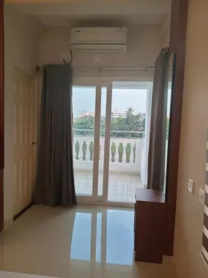 a room with a large window with a view of a balcony at Dew Dreams Periyar Castle in Alwaye