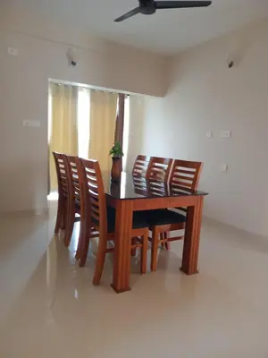 a dining room table and chairs with a plant on it at Dew Dreams Periyar Castle in Alwaye