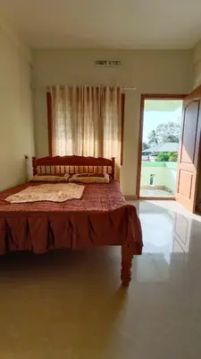 a bed in a room with a large window at Serenity Suite in Trichūr