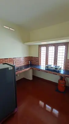an empty room with a counter and some windows at Serenity Suite in Trichūr