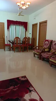 a living room with chairs and a table and a couch at Serenity Suite in Trichūr
