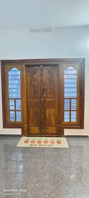 a room with two wooden doors and a concrete floor at The Bulbul Nest Homestay in Gūdalūr