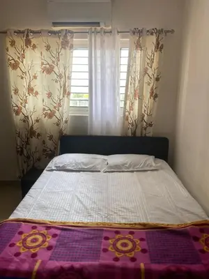 a bedroom with a bed with a purple blanket on it at Peace of mind in Kakkayam