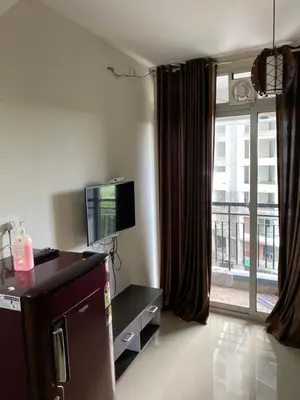 a living room with a tv and a large window at Peace of mind in Kakkayam