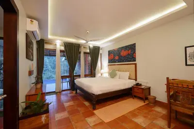 a bedroom with a bed and some windows at Mayaahi Resorts & Spa in Nilambūr