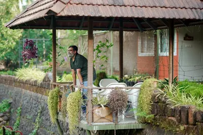 a man standing under a pavilion in a garden at Mayaahi Resorts & Spa in Nilambūr