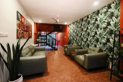 a living room with couches and a wall mural at Mayaahi Resorts & Spa in Nilambūr