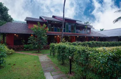 a red house with a pathway in front of it at Mayaahi Resorts & Spa in Nilambūr