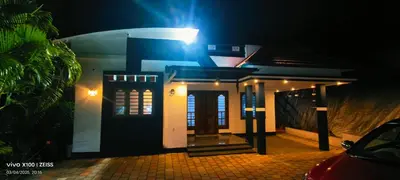 a house with a light on it at night at The Bulbul Nest Homestay in Gūdalūr
