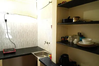 a small kitchen with a sink and a counter at Manasthala- Srinivas House Room1 in Mysore