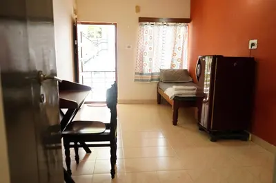 a room with a piano and a couch and a window at Manasthala- Srinivas House Room1 in Mysore