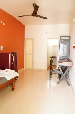 a room with orange walls and a chalkboard on the wall at Manasthala- Srinivas House Room1 in Mysore