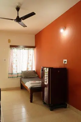 a room with a bed and a ceiling fan at Manasthala- Srinivas House Room1 in Mysore