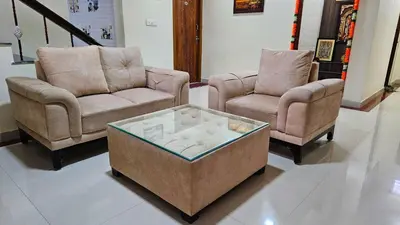 a living room with two chairs and a coffee table at Mahalakshmi Residency in Coimbatore