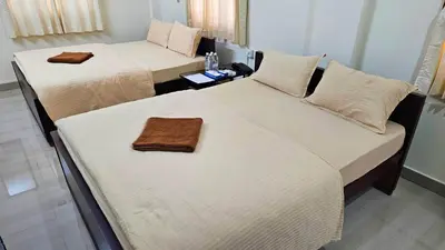two beds in a hotel room with towels on them at Mahalakshmi Residency in Coimbatore