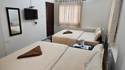 a hotel room with two beds and a mirror at Mahalakshmi Residency in Coimbatore