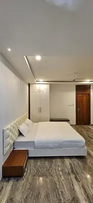 a bedroom with a large bed and a wooden floor at Barkah inn in Kannur