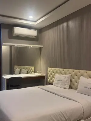 a bedroom with a large bed and a desk at Barkah inn in Kannur