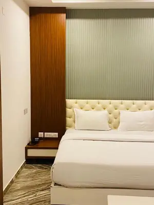 a bedroom with a large bed with white pillows at Barkah inn in Kannur