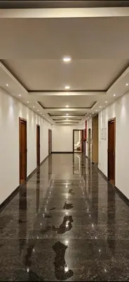 an empty hallway in a building with water on the floor at Barkah inn in Kannur