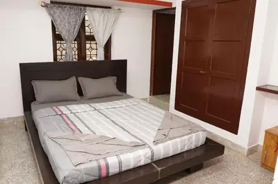 a bed in a room with a brown cabinet at Lands End in Madikeri