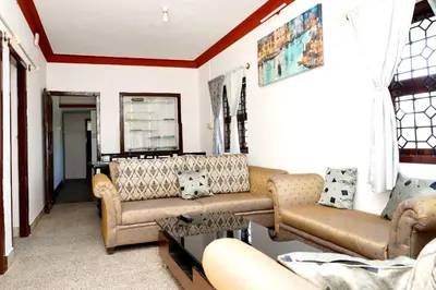 a living room with two couches and a table at Lands End in Madikeri