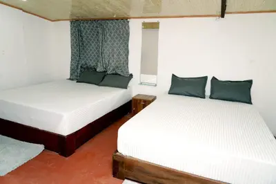 two beds in a small room with at Lands End in Madikeri