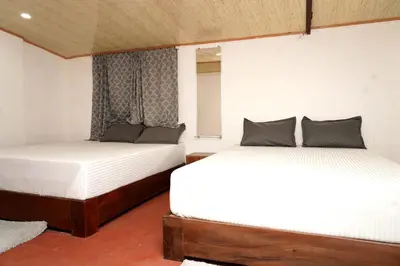 a bedroom with two beds and a window at Lands End in Madikeri