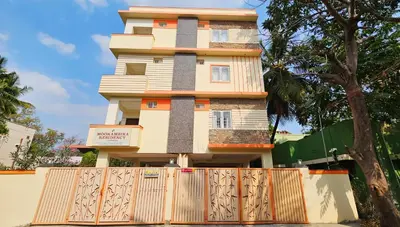 a building with a fence in front of it at Mookambika Serviced Apartment in Coimbatore