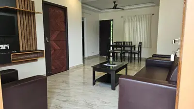 a living room with a couch and a table at Mookambika Serviced Apartment in Coimbatore