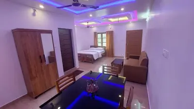 a living room with a table and a room with a bed at Marayoor home stay in Marayoor