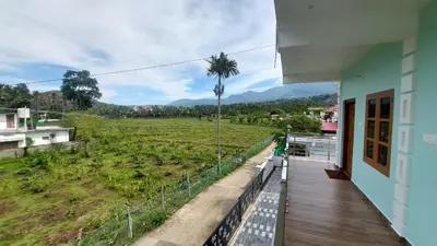 a balcony of a house with a view of a field at Marayoor home stay in Marayoor