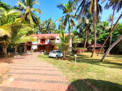 a house with a car parked in front of it at Club 7 Beach Resort in Kannur