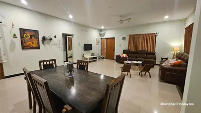 a dining room and living room with a table and chairs at SHI's Shenba 3BHk Villa Near Ganga Hospital Coimbatore in Coimbatore