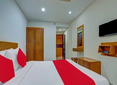 a bedroom with a red and white bed and a television at Marhaba tourist home in Kunnamangalam